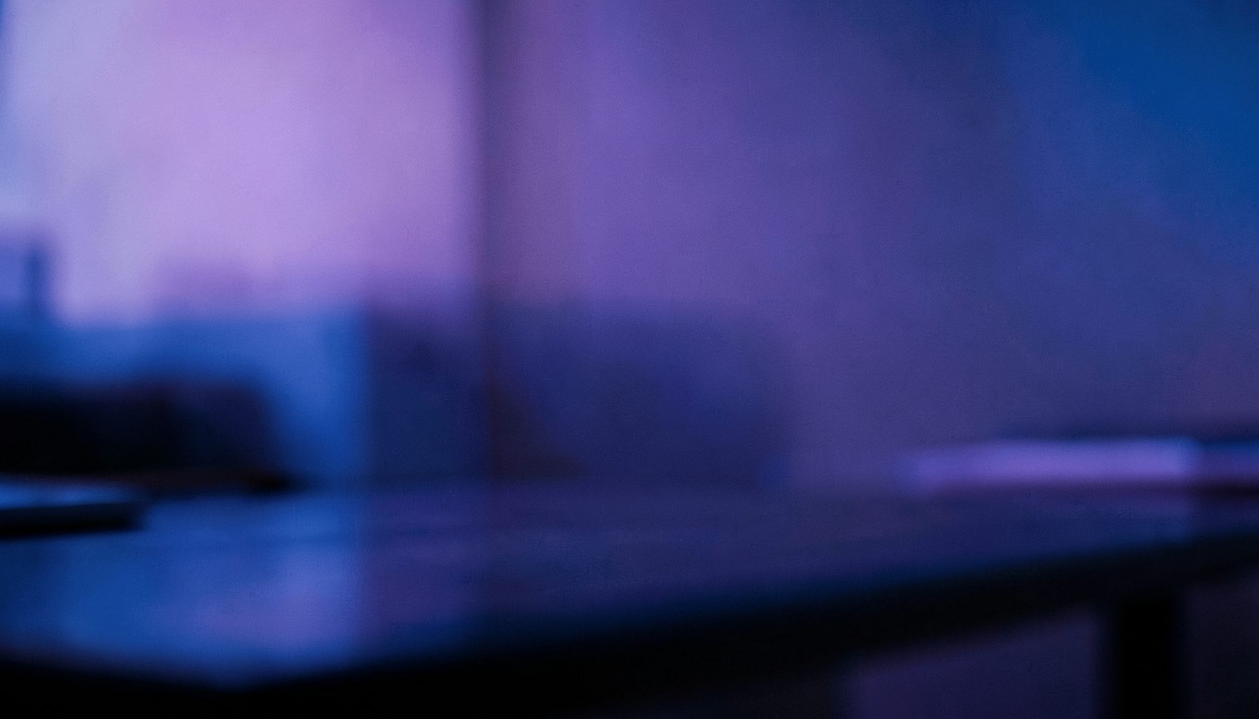Dark gradient workspace with soft purple and indigo tones, a clean desk surface with subtle reflections, and a calm focused atmosphere